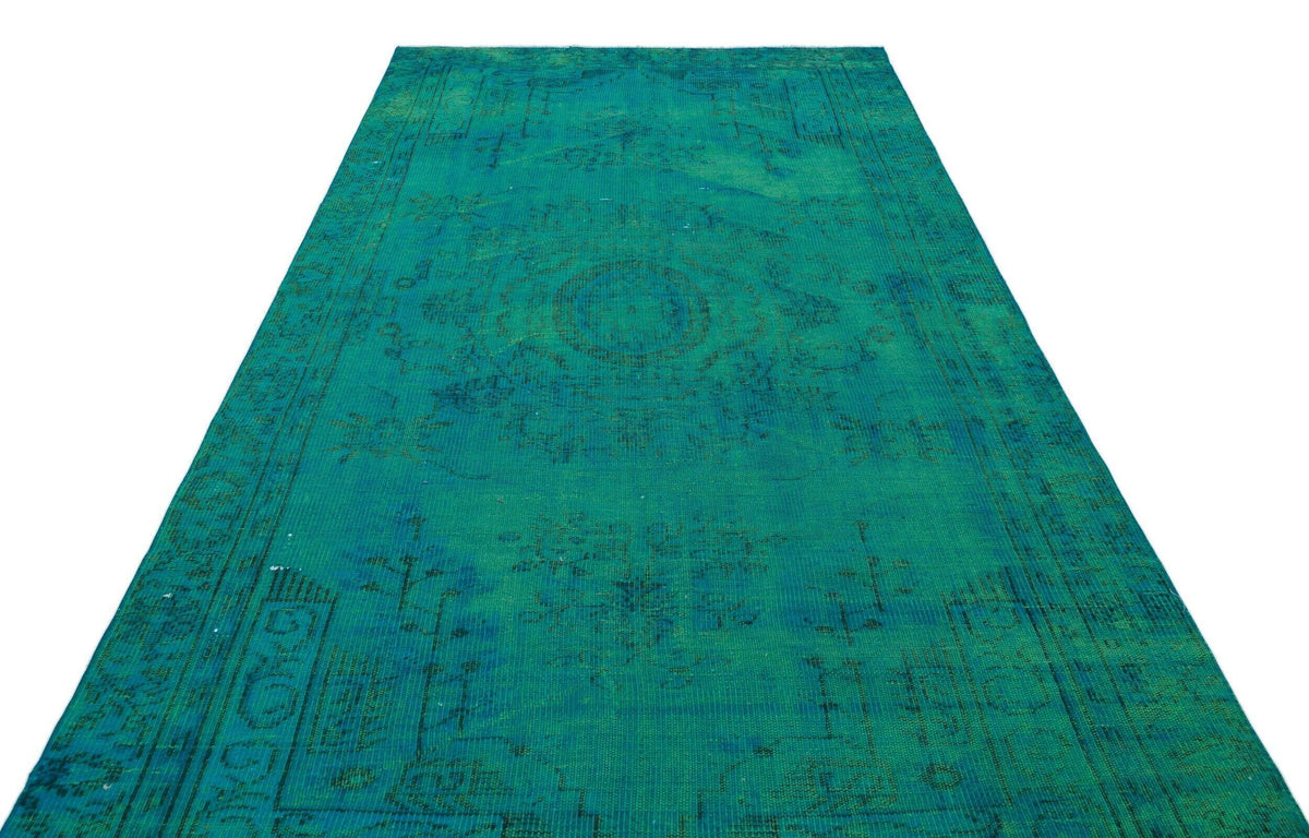 Emerald green vintage-style rug with a faded, distressed traditional medallion pattern on a white background.