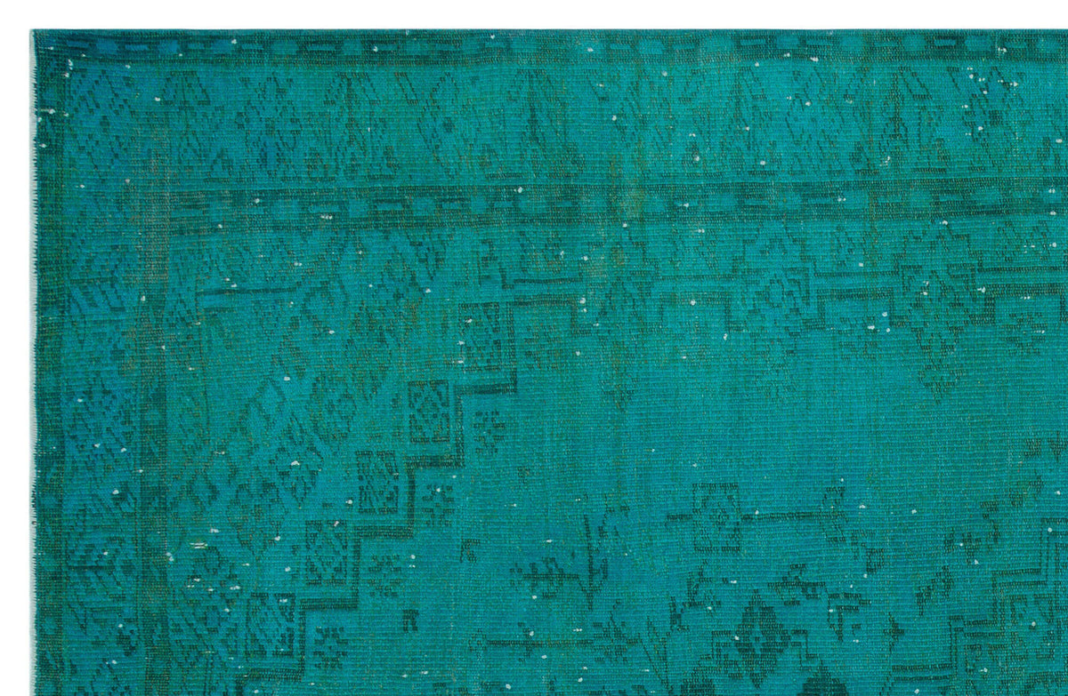 Teal distressed rug with a faded traditional geometric border and central medallion pattern.
