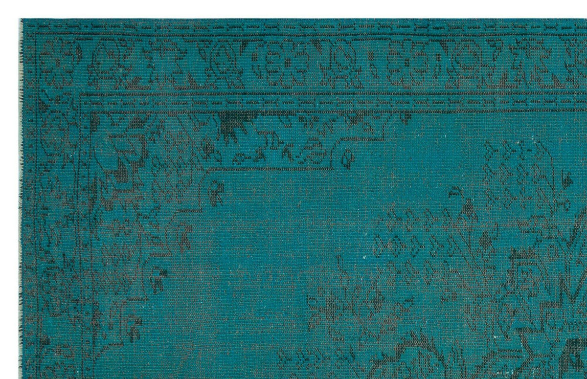 Teal rug with a distressed black traditional floral border and medallion pattern.