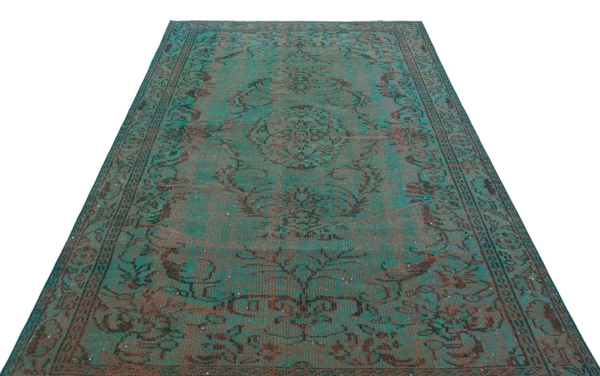 Teal and dark brown distressed vintage-style rug with a central medallion and ornate floral border.
