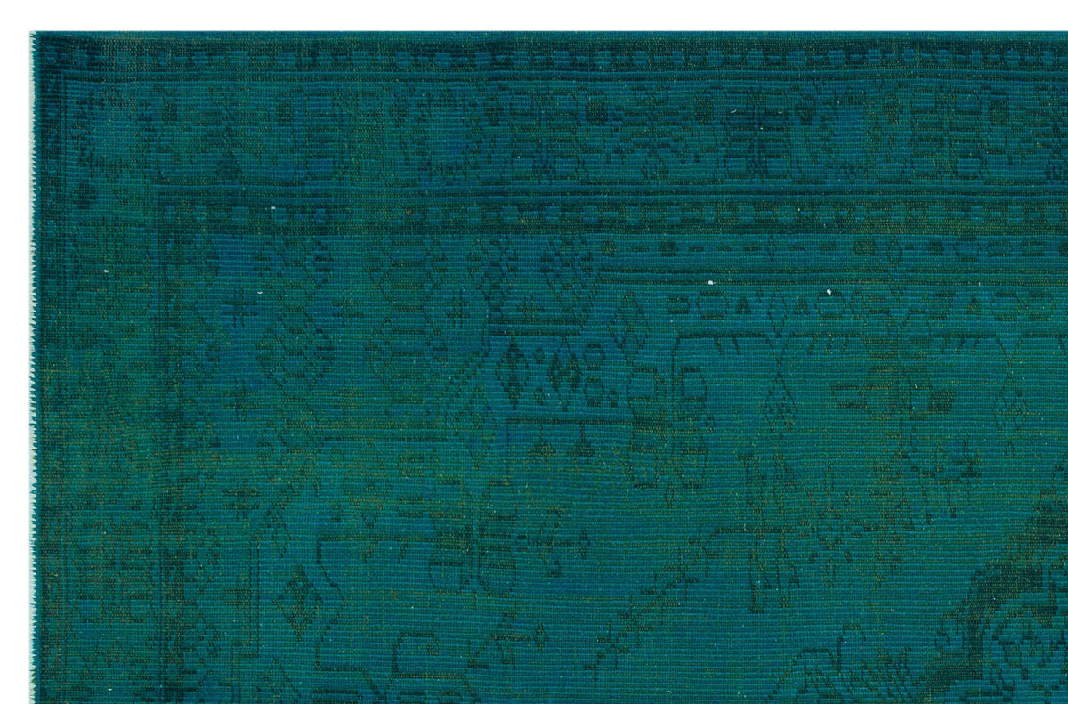 Teal monochromatic rug with a distressed traditional Persian-style pattern and a geometric border.