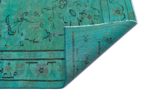 Load image 1 in gallery view. Teal vintage-style rug with a distressed black and grey geometric pattern, shown with a corner folded over.