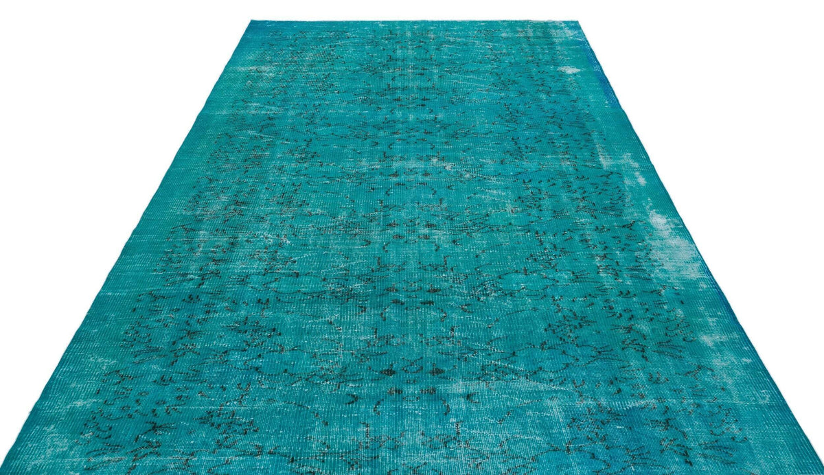 Teal distressed vintage-style rug with a faded black traditional pattern on a white background.