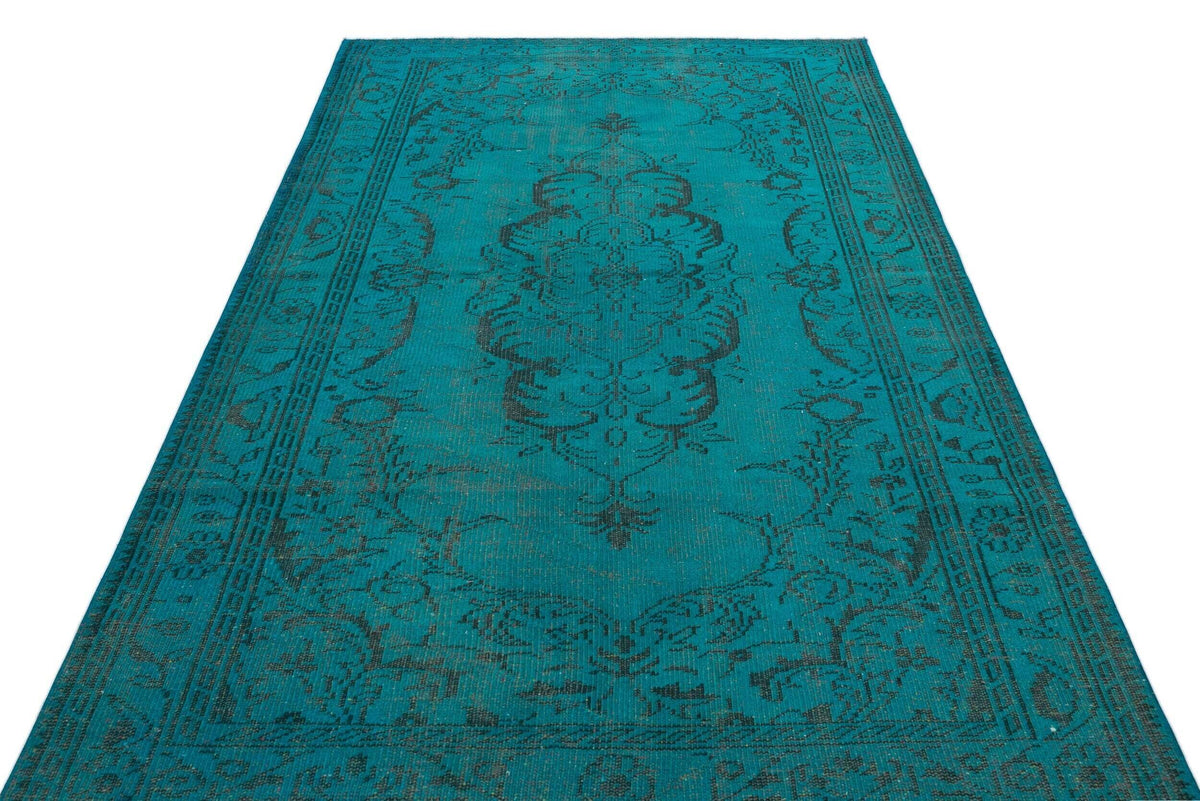 Teal and black vintage-style rug with a central medallion and ornate border on a white background.