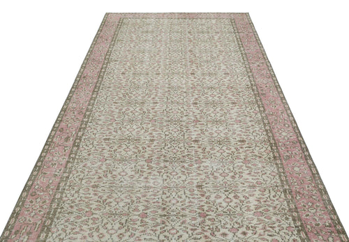 Load image 1 in gallery view. Cream and pink vintage-style rug with a distressed floral medallion pattern and a wide decorative border.