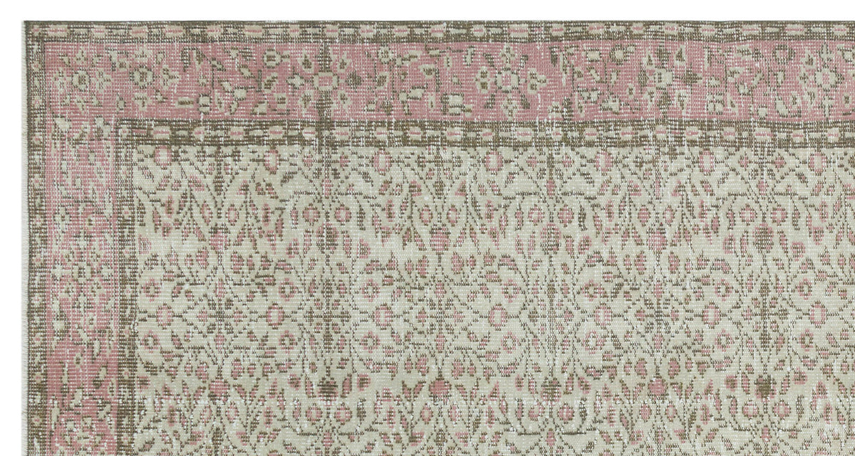 Distressed pink, beige, and taupe rug with a traditional floral medallion border and intricate botanical pattern.