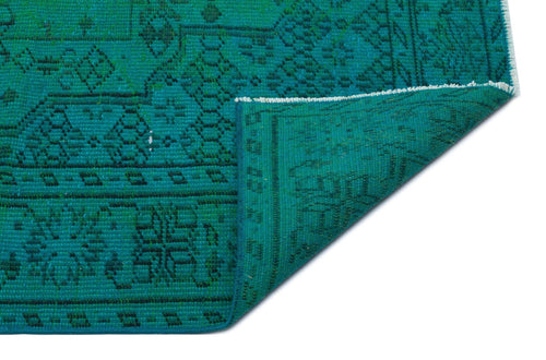 Load image 1 in gallery view. Teal rug with a black geometric pattern and a folded corner showing the underside on a white background.