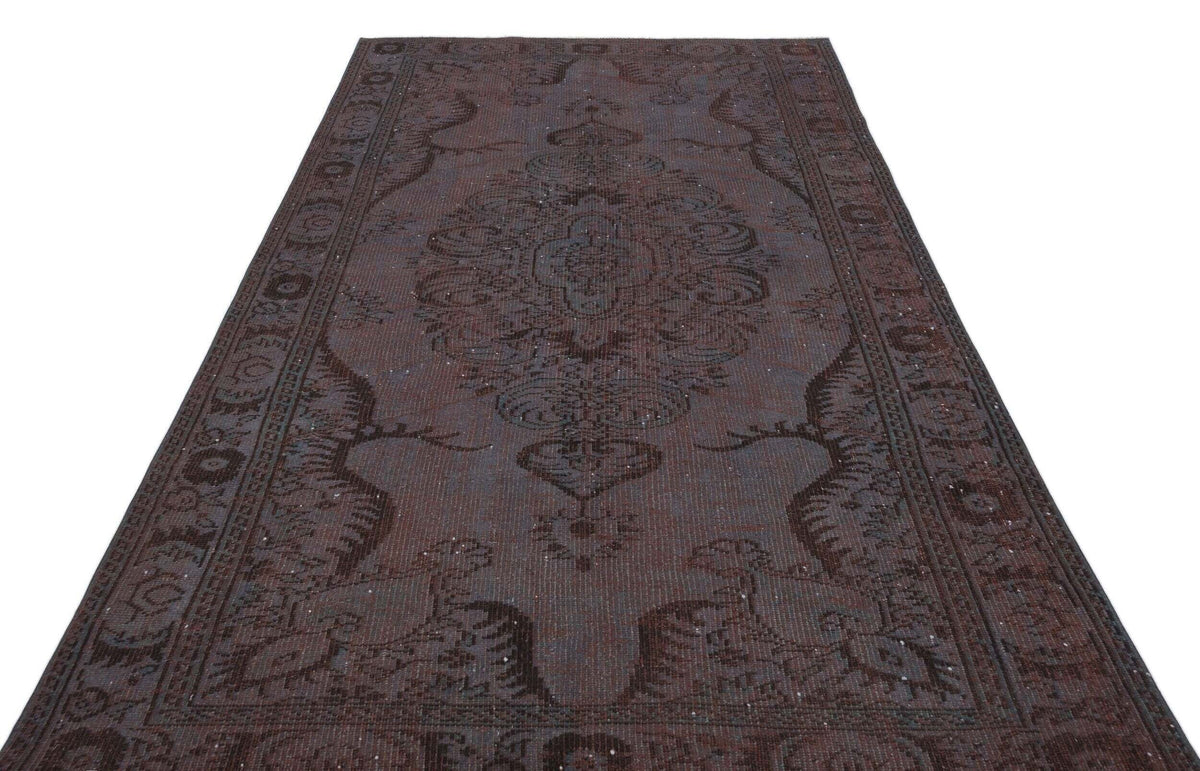 Dark brown traditional rug with a central medallion and ornate border pattern on a white background.