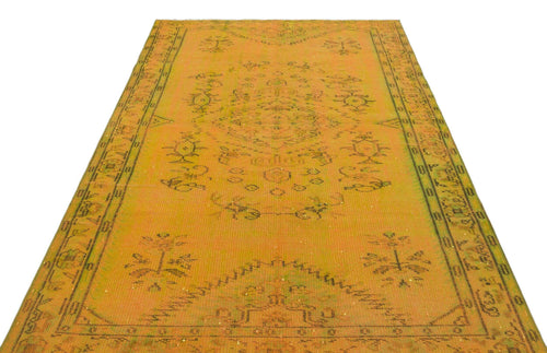 Load image 1 in gallery view. Mustard yellow vintage rug with a dark green central medallion and geometric border pattern on a white background.