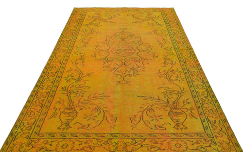 Load image 1 in gallery view. Mustard yellow vintage-style rug with a dark brown floral medallion and urn motif, isolated on a white background.