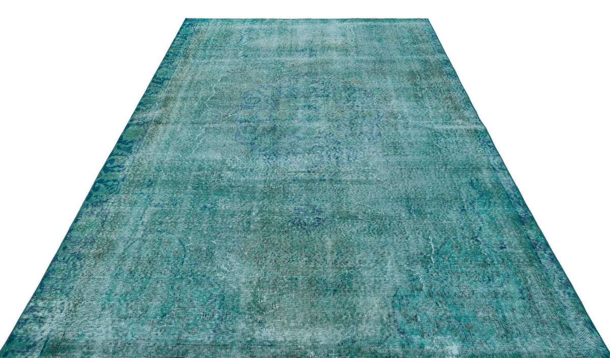 Teal and blue distressed vintage-style rug with a faded traditional medallion pattern on a white background.