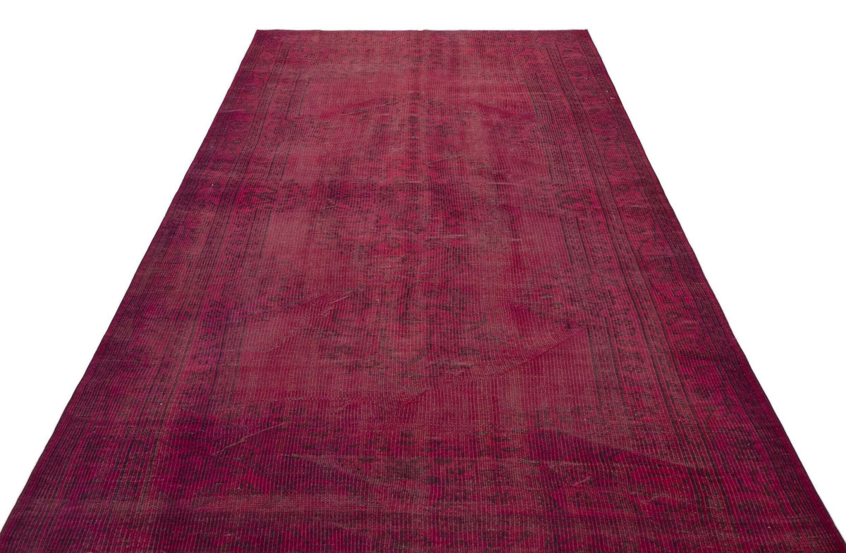Deep magenta vintage-style rug with a faded, distressed traditional medallion pattern on a white background.