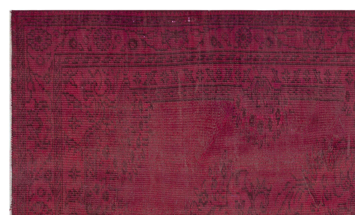 Deep magenta rug with a distressed, faded black traditional border and ornate floral pattern.