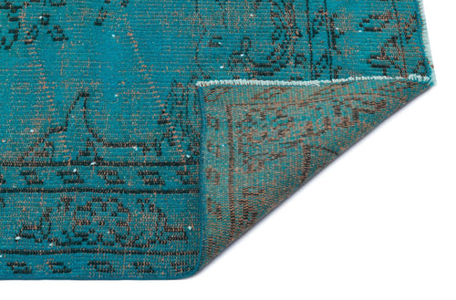 Load image 1 in gallery view. Teal and brown distressed rug with a traditional medallion pattern, shown with a corner folded over.