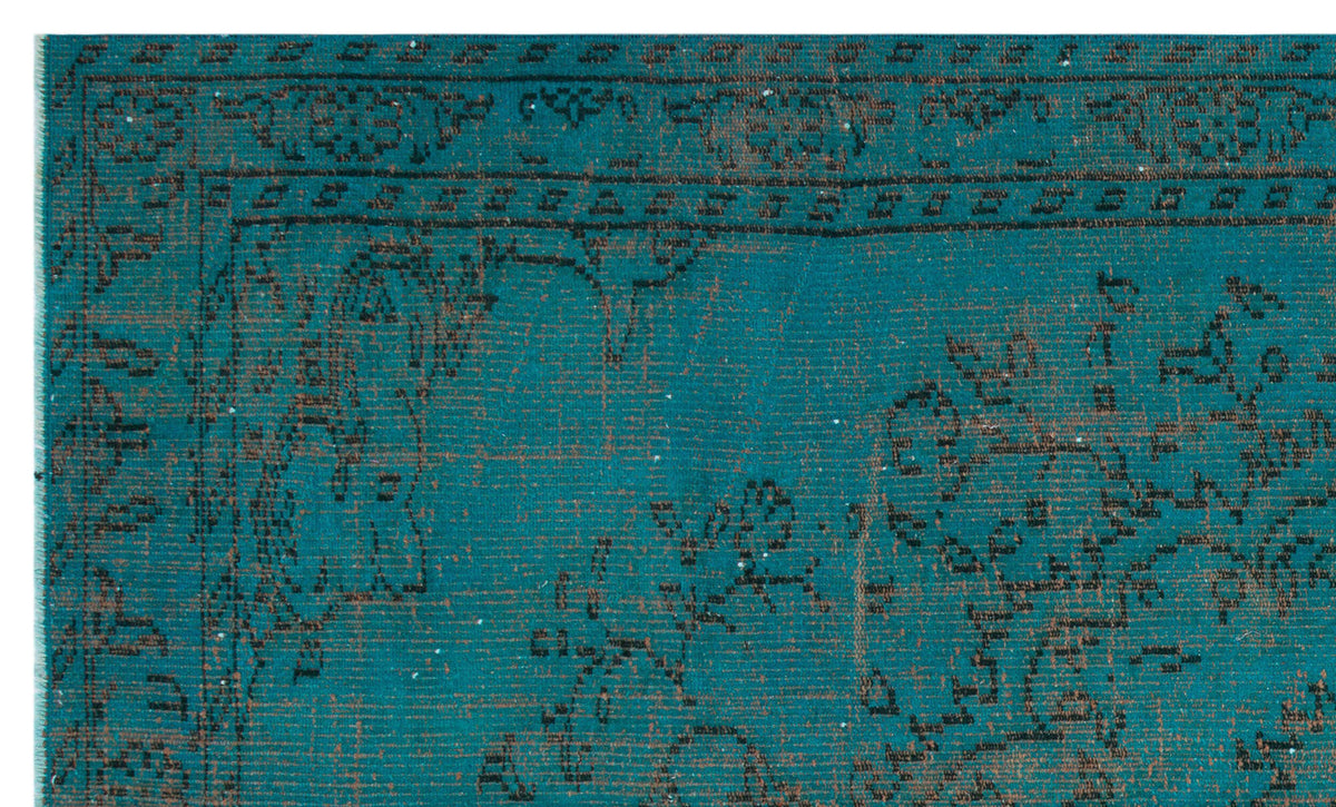 Teal and black distressed rug with a traditional ornate border and floral medallion pattern.