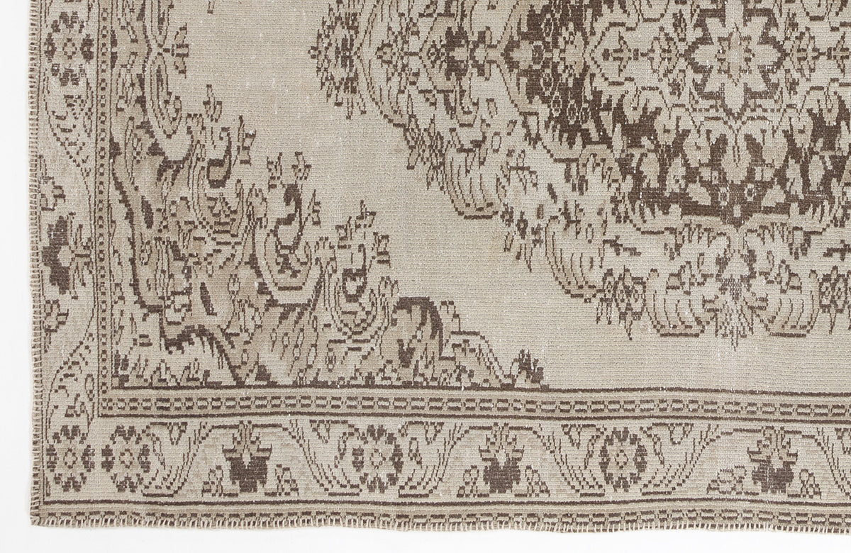Beige and dark brown rug with a distressed traditional medallion pattern and a geometric border.