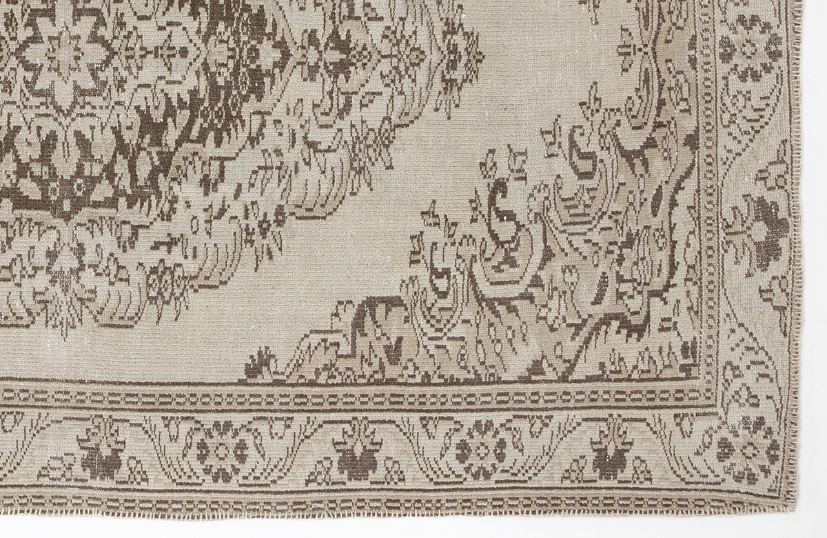 Beige and brown vintage-style rug with a traditional floral medallion pattern and a detailed border.