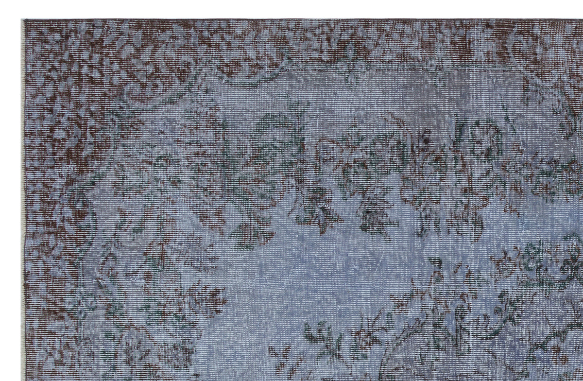 Blue and brown distressed rug with a faded traditional floral medallion pattern.