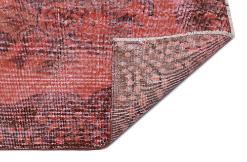 Load image 1 in gallery view. Distressed coral and brown rug with a floral medallion pattern, showing the underside corner on a white background.