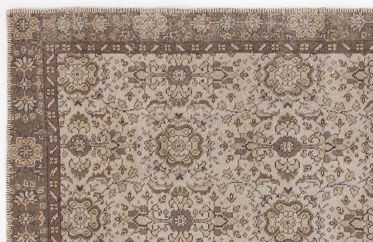 Distressed brown and beige rug with a traditional floral medallion pattern and a wide decorative border.
