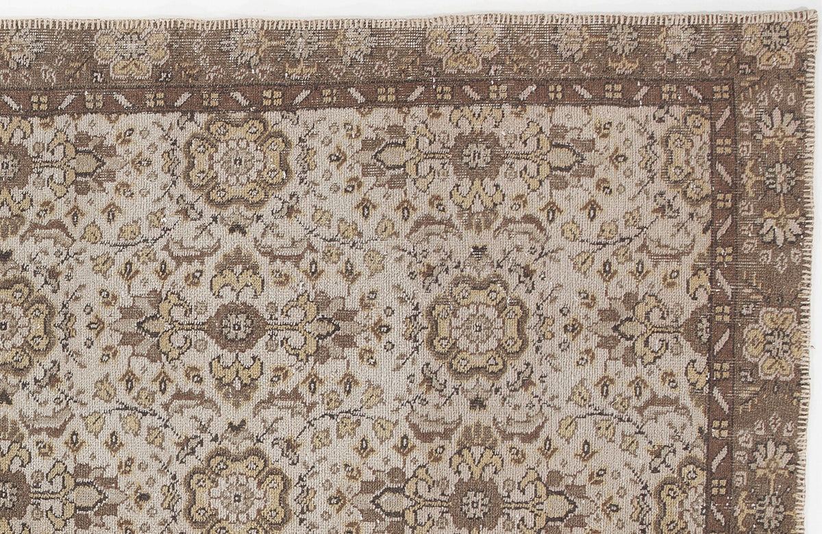 Beige and brown traditional rug with a distressed floral medallion pattern and a wide decorative border.