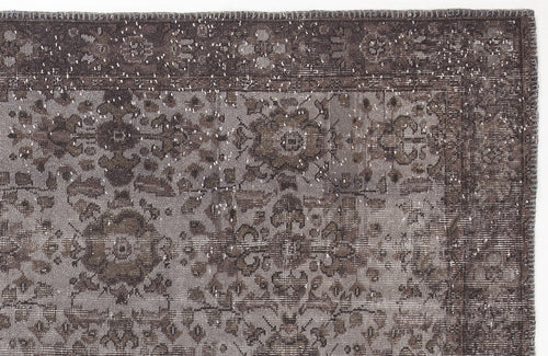 Load image 1 in gallery view. Dark brown and grey distressed rug with a traditional floral medallion pattern and a bordered edge.
