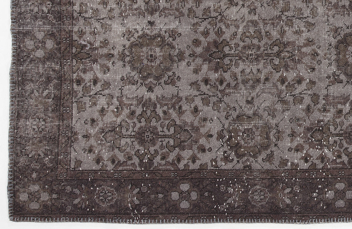 Charcoal and grey distressed rug with a traditional floral medallion pattern and a wide decorative border.