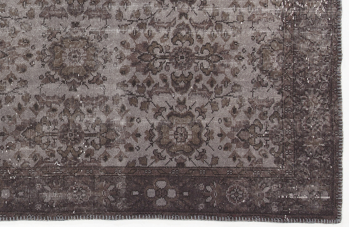 Dark grey and charcoal distressed rug with a traditional floral medallion pattern and a wide decorative border.