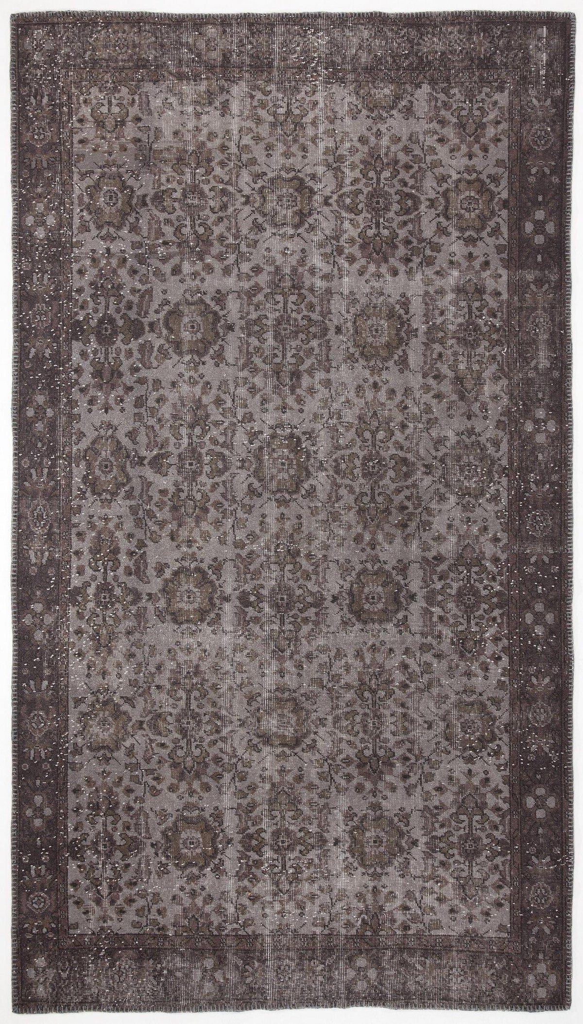 Dark charcoal and grey distressed rug with a traditional floral medallion pattern and a wide decorative border.