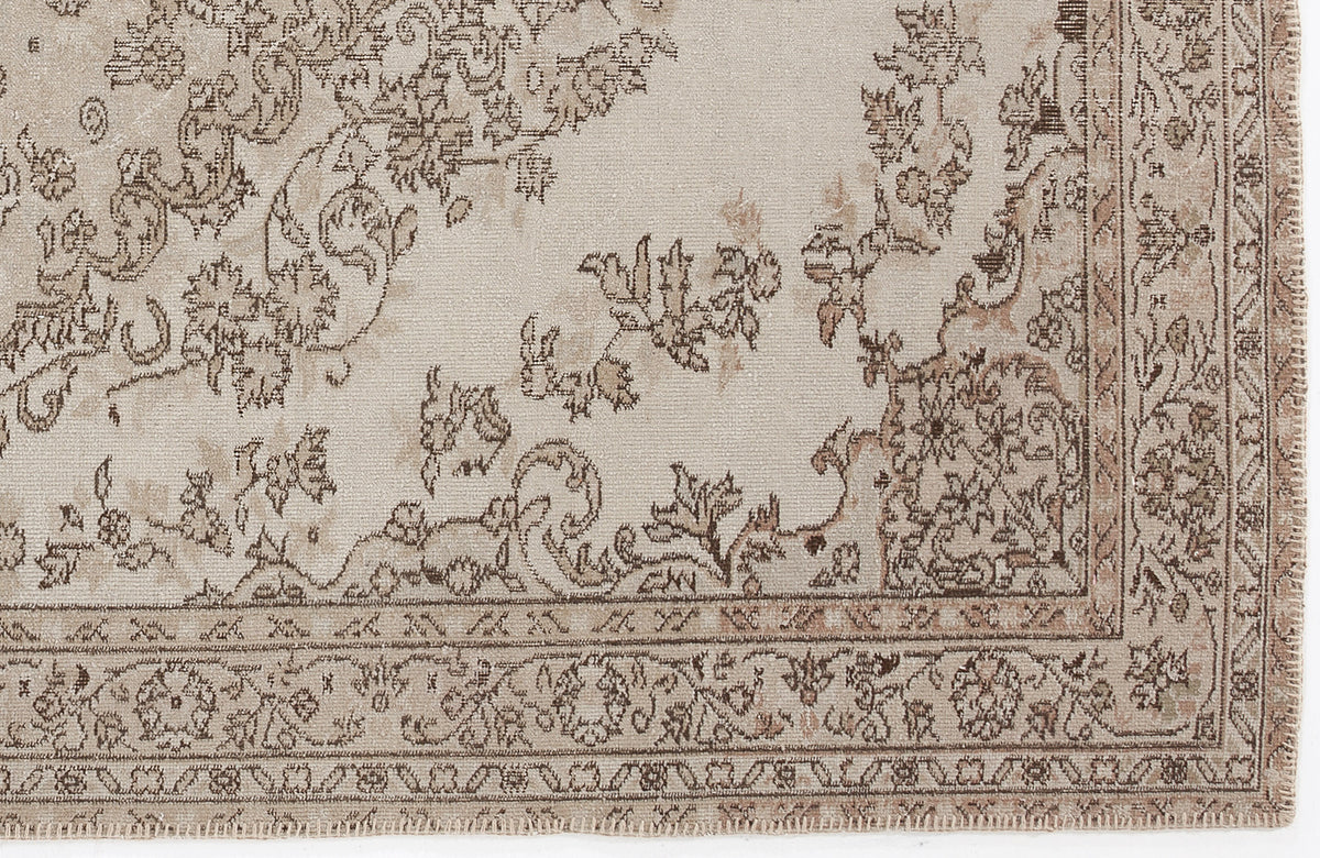 Beige and brown rug with a distressed floral medallion pattern and a detailed decorative border.