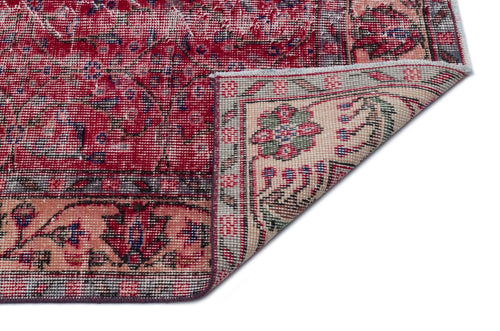 Load image 1 in gallery view. Distressed red and cream traditional rug with a floral medallion pattern, shown with a corner folded over.