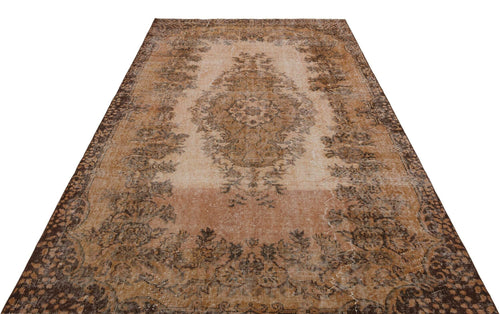 Load image 1 in gallery view. Distressed brown and beige vintage-style rug with a central floral medallion and ornate border on a white background.