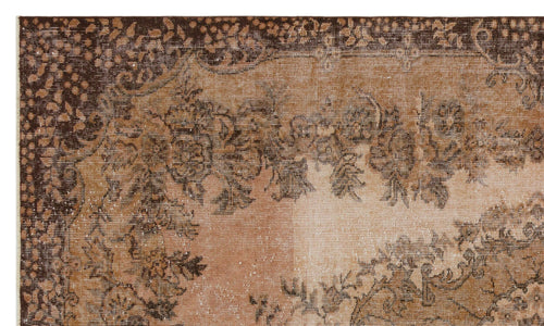 Load image 1 in gallery view. Distressed brown and tan traditional rug with a faded floral medallion pattern.