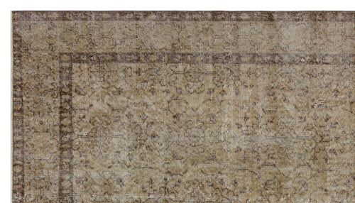 Load image 1 in gallery view. Brown and beige vintage-style rug with a distressed traditional medallion pattern and a geometric border.