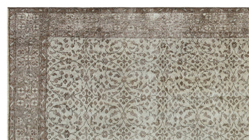 Load image 1 in gallery view. Brown and beige vintage-style rug with a distressed floral medallion pattern and a wide decorative border.