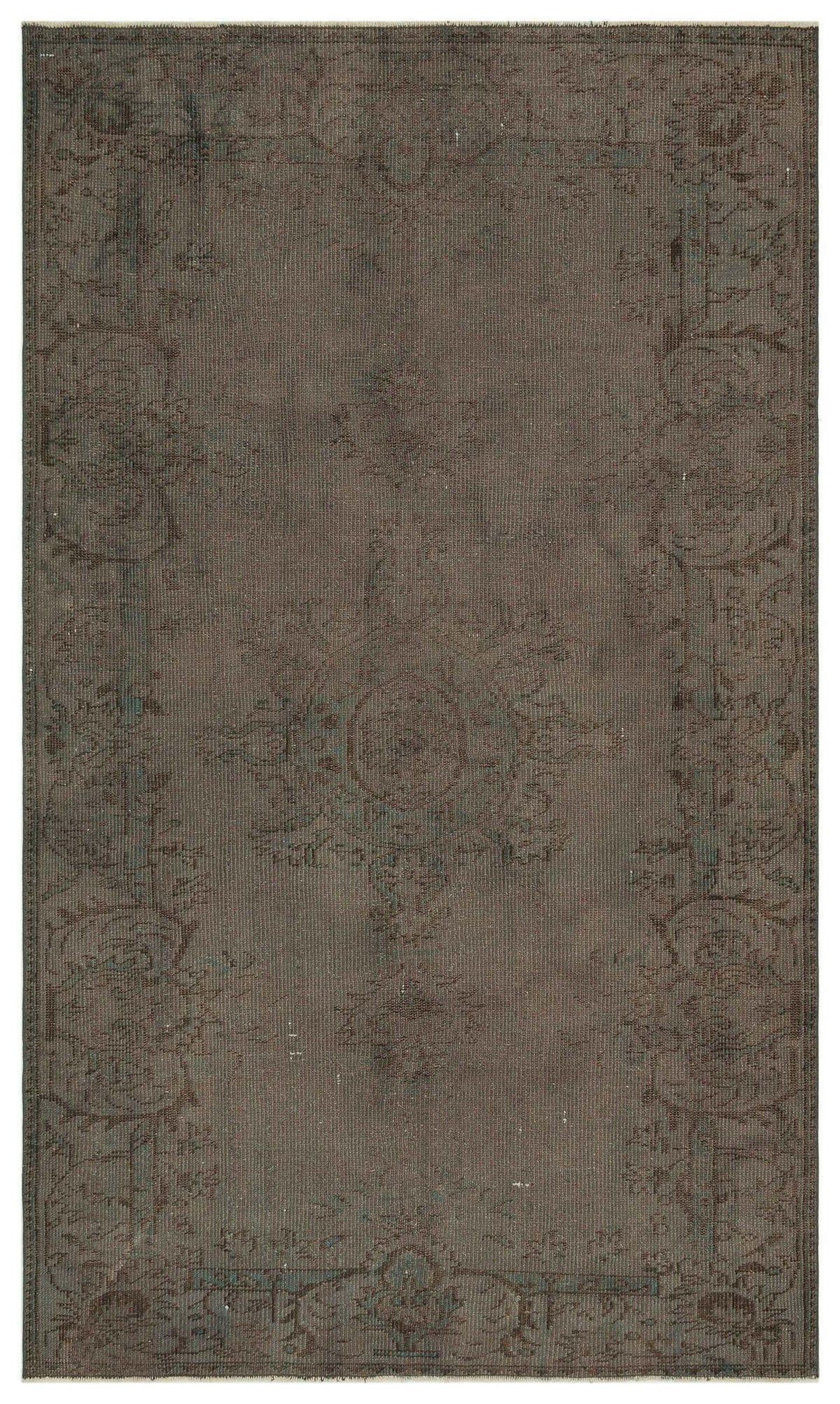 Dark brown distressed rug with a faded central medallion and ornate floral border in muted teal and charcoal tones.
