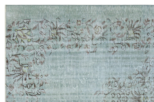Load image 1 in gallery view. Sage green rug with a distressed, faded floral pattern in brown and cream.