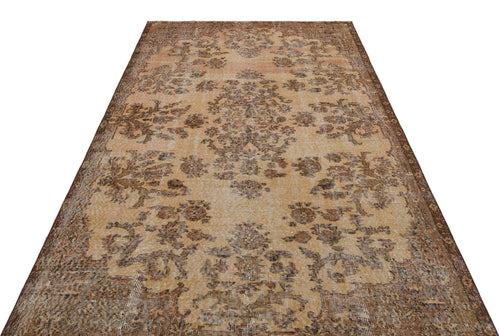Load image 1 in gallery view. Distressed tan and brown vintage-style rug with a central floral medallion and ornate border.