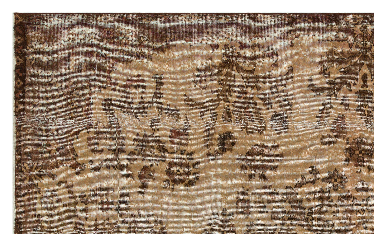 Distressed brown and tan vintage-style rug with a faded floral medallion pattern.
