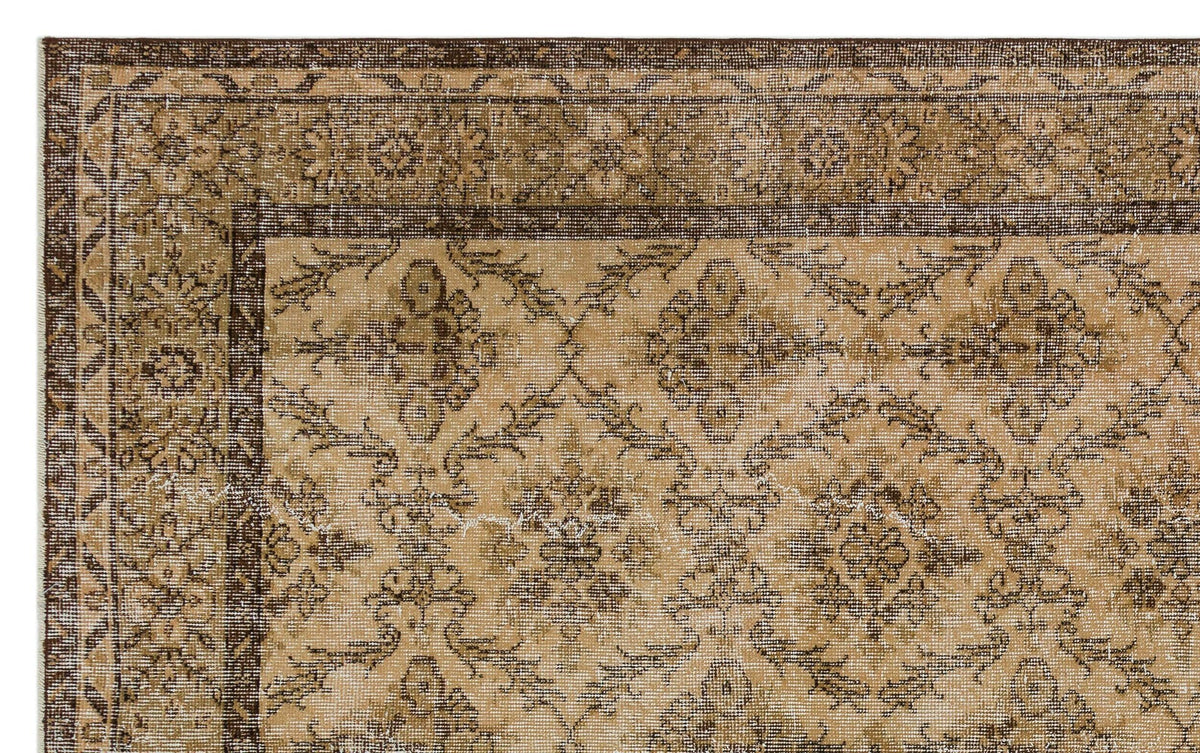 Tan and dark brown traditional rug with a distressed floral medallion pattern and a wide decorative border.