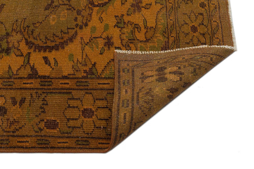 Load image 1 in gallery view. Mustard and brown traditional rug with a floral border and corner fold, isolated on a white background.