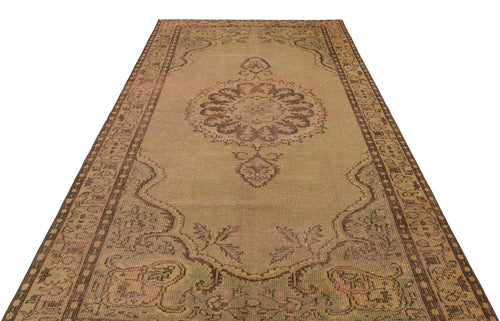 Load image 1 in gallery view. Distressed tan and brown vintage-style rug with a central medallion and ornate border pattern on a white background.