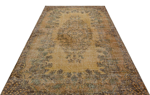 Load image 1 in gallery view. Distressed ochre and brown vintage-style rug with a central floral medallion and ornate border on a white background.