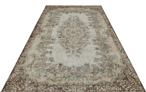Load image 1 in gallery view. Distressed beige and brown traditional rug with a central floral medallion and ornate border on a white background.