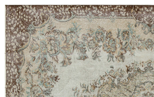 Load image 1 in gallery view. Distressed beige, brown, and sage green rug with a traditional floral medallion pattern and a wide decorative border.