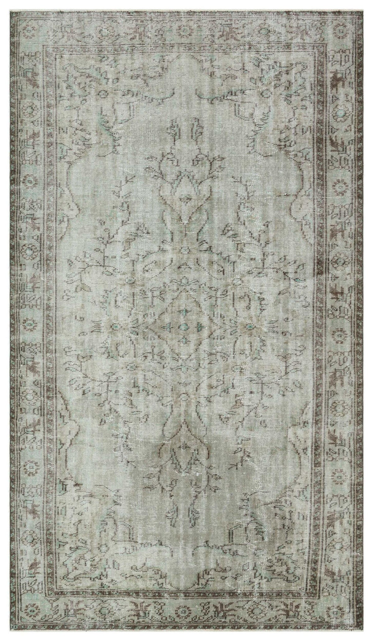 Distressed grey and brown vintage-style rug with a central floral medallion and ornate border pattern.