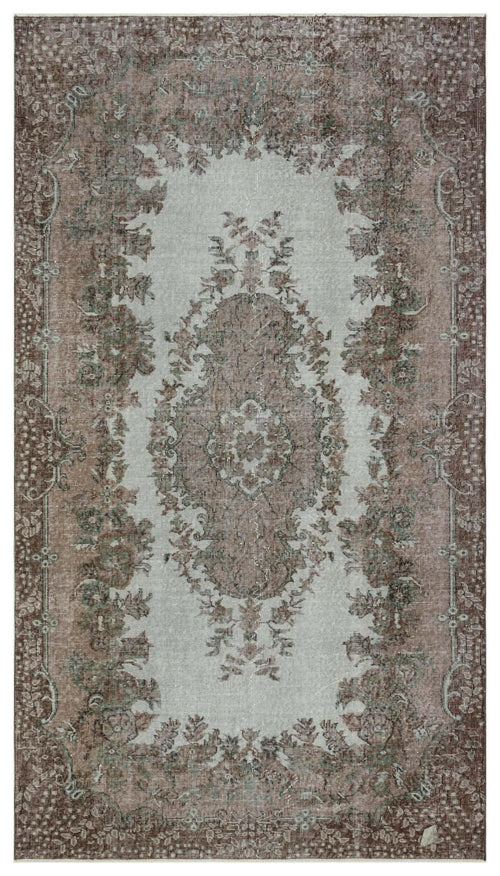 Load image 1 in gallery view. Distressed brown and light gray traditional rug with a central floral medallion and ornate border.
