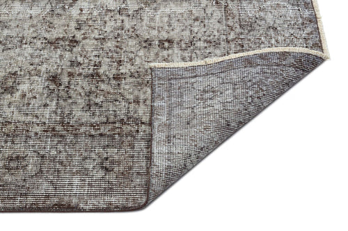 Load image 1 in gallery view. Distressed brown and cream traditional rug with a folded corner revealing the woven backing and fringe edge.