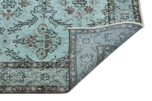 Load image 1 in gallery view. Light blue traditional rug with brown and charcoal floral motifs, shown with a corner folded over on a white background.