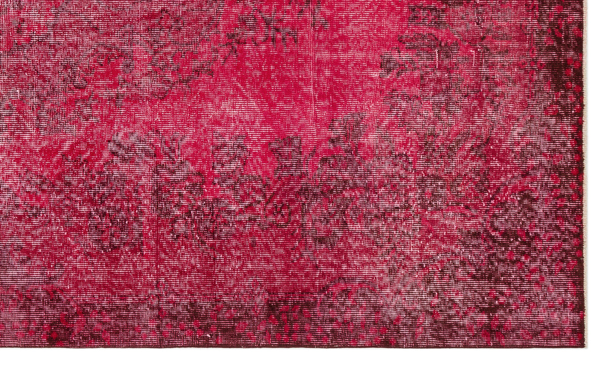 Magenta and dark burgundy distressed rug with a faded traditional floral medallion pattern.